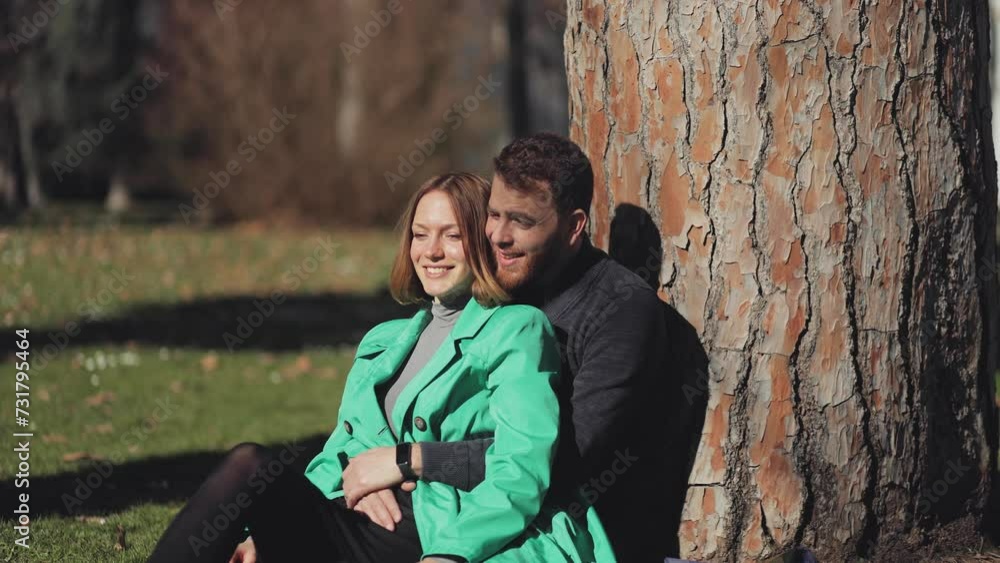 A couple on a date in the park, lying on the grass near a huge tree, hugs, relaxation, date, comfort, flirting, convenience, relationships, coziness, sunbath, meditation in nature, happiness, love A couple on a date in the park, lying on the grass near a huge tree, hugs, relaxation, date, comfort, flirting, convenience, relationships, coziness, sunbath, meditation in nature, happiness, love