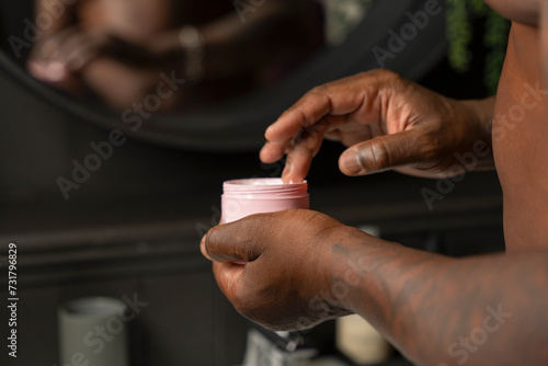 Man taking moisturizer from cream jar