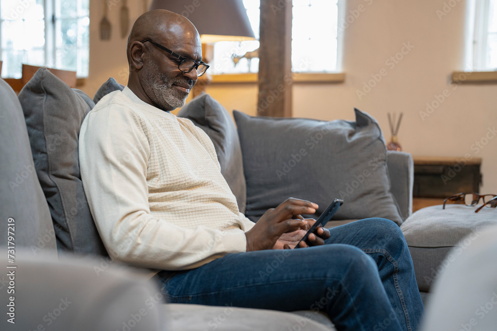 Senior man sitting on sofa and using phone Senior man sitting on sofa and using phone
