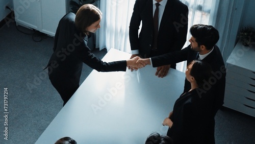 Top view of professional business team shaking hand and clapping hands to celebrate young businesswoman getting promotion. Diverse business people congratulate for successful project. Directorate. photo