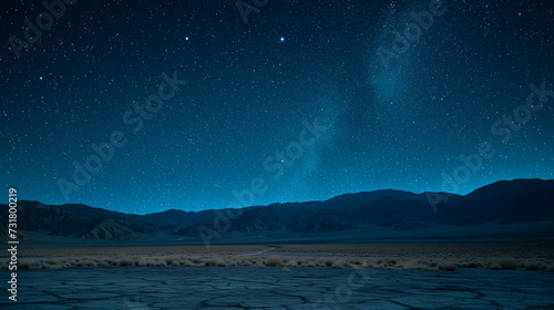 Desert with distant mountains under a starry night sky © AnnTokma