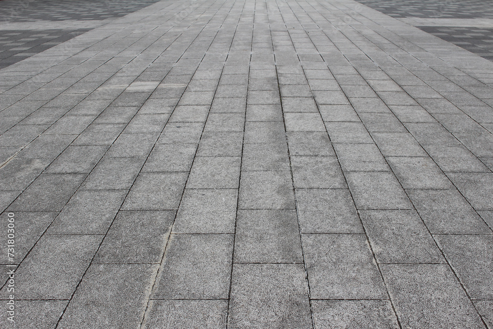Texture of square cobblestone. Pattern of sidewalk tiles in the street.