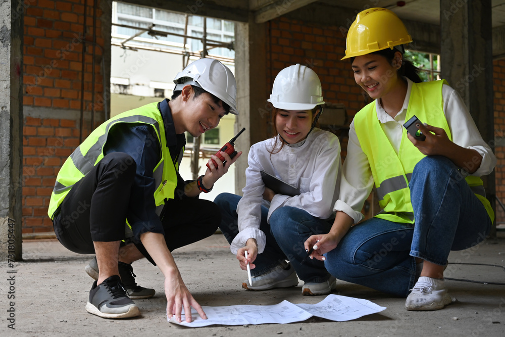 Group of construction worker team working together and discussing planning build process at construction site Group of construction worker team working together and discussing planning build process at construction site