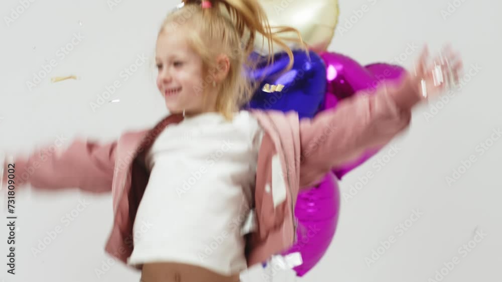 Cute girl dancing on a white background with balloons. The concept of children's theater productions and developing acting circles and children's parties. Cute girl dancing on a white background with balloons. The concept of children's theater productions and developing acting circles and children's parties.