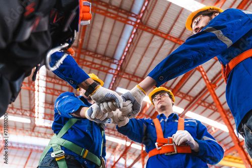 Craftsmen team is successful and makes high five motivation in a factory hallProfessional industry engineer and factory foreman worker team person Wearing safety helmet hard hat, Technician Team. © Hip.hub