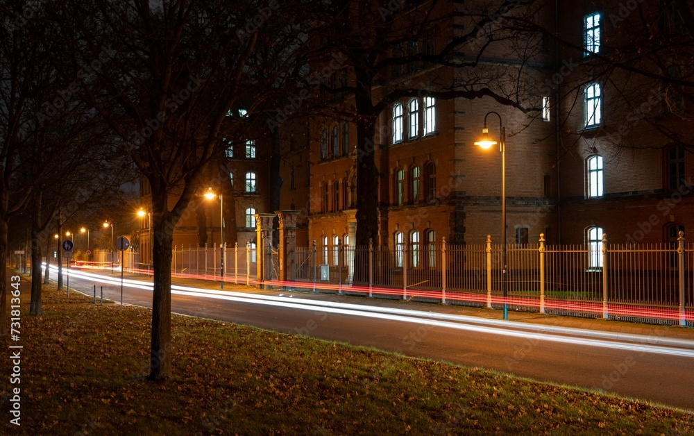 View of a bustling city street at night, illuminated by the light trails of passing cars