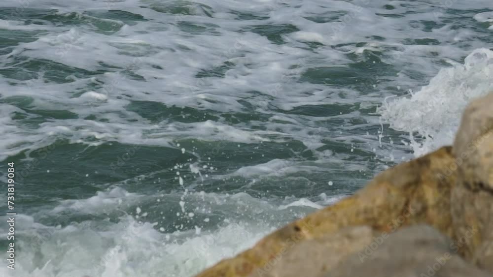 Closeup of splashing waves on rocky hill with foam Closeup of splashing waves on rocky hill with foam