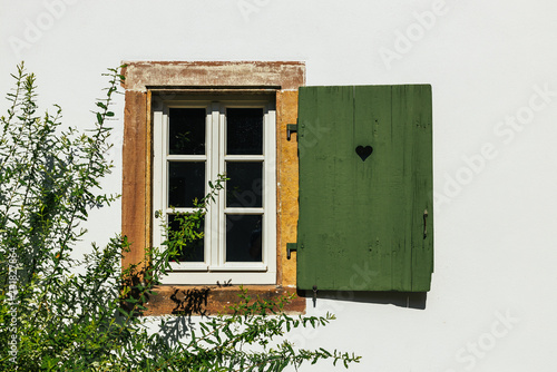 Fenster an Bauernhof mit grünem Fensterladen und Herz