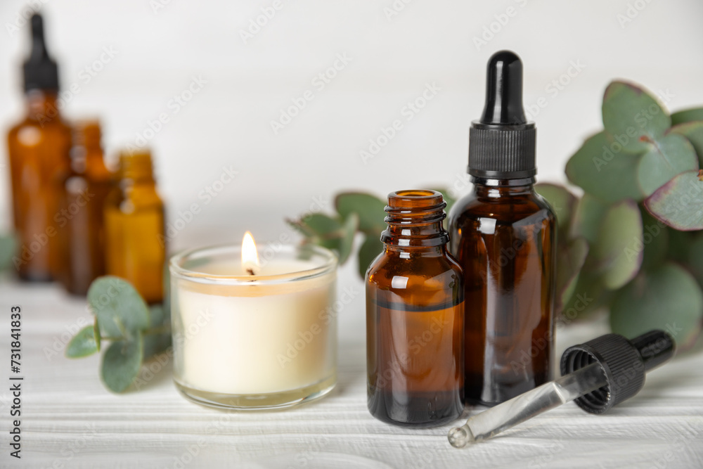 Eucalyptus essential oil in a glass bottle with green eucalyptus leaves on a textured wooden background. Aromatherapy concept. Spa. Natural organic ingredients for cosmetics and body care.Copy space Eucalyptus essential oil in a glass bottle with green eucalyptus leaves on a textured wooden background. Aromatherapy concept. Spa. Natural organic ingredients for cosmetics and body care.Copy space
