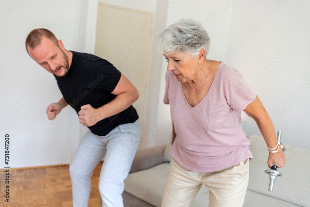Obraz premium Elderly woman, dumbbells and rehabilitation therapist for exercise in a nursing home. Happy senior patient with physiotherapist man or nurse for healing, health and physiotherapy for muscle and body.