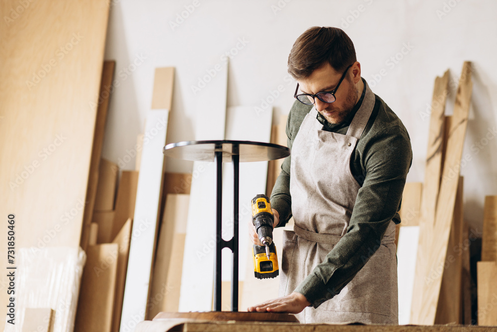 Carpenter with coffee table in the manufacturing Carpenter with coffee table in the manufacturing
