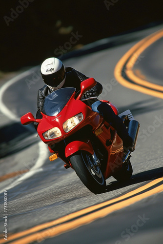 A man is riding a red motorcycle in an inland area that has good road quality.