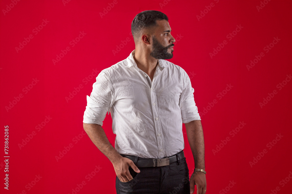 Man, with a beard, in a white shirt, with various facial expressions, on a red studio background Man, with a beard, in a white shirt, with various facial expressions, on a red studio background