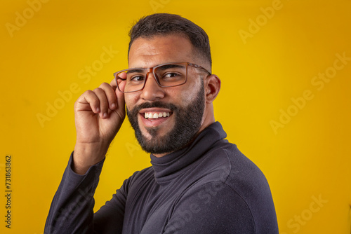 Man with beard wearing glasses, black shirt, with various facial expressions