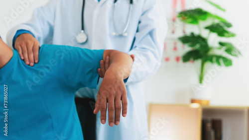 Schilderij op canvas A physical therapist is treating a man with shoulder pain and suffering from frozen shoulder,pain and stiffness,unable to move,difficulty lifting his arm,male people with calcific tendonitis