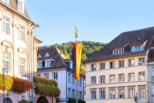 administration building German city of Heidelberg with long national flag, street of historic building, beautiful facade ancient house European German architecture photo