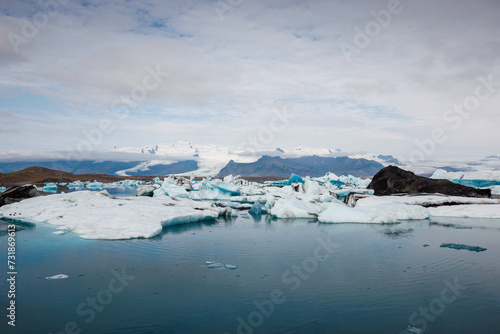 Icelandic glacial scenery, magnificent ice form, iceberg floating in the calm blue water, aerial shot. Concepts of unique nature and impressive sights.