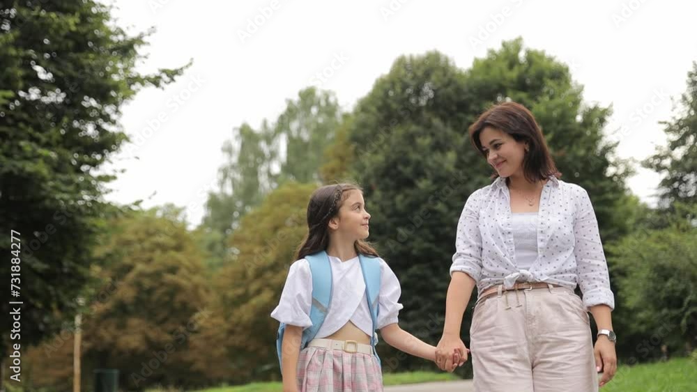 Happy woman and girl smiling under a tree, enjoying a sunny day in the park. Happy woman and girl smiling under a tree, enjoying a sunny day in the park.