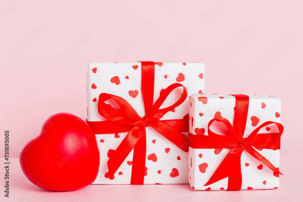 gift box with red bow and red heart on colored background. Perspective view. Flat lay gift box with red bow and red heart on colored background. Perspective view. Flat lay