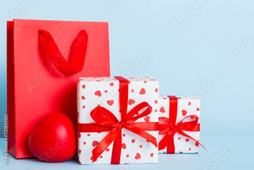 Shopping bag with gift box on colored background perspecrive view. Space for text holiday concept