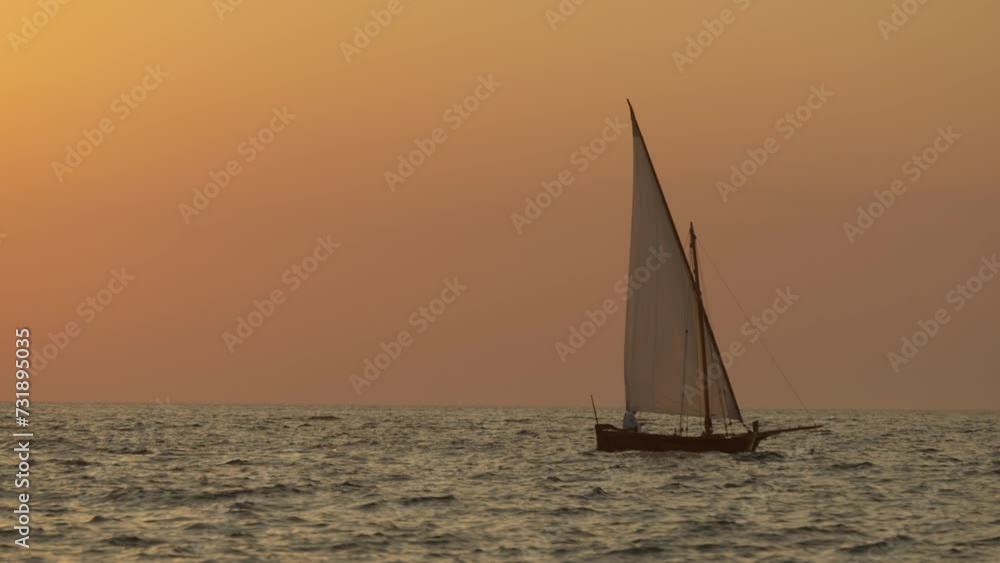Man Sails the Old Medieval Boat on the Adriatic Sea at Sunset Man Sails the Old Medieval Boat on the Adriatic Sea at Sunset