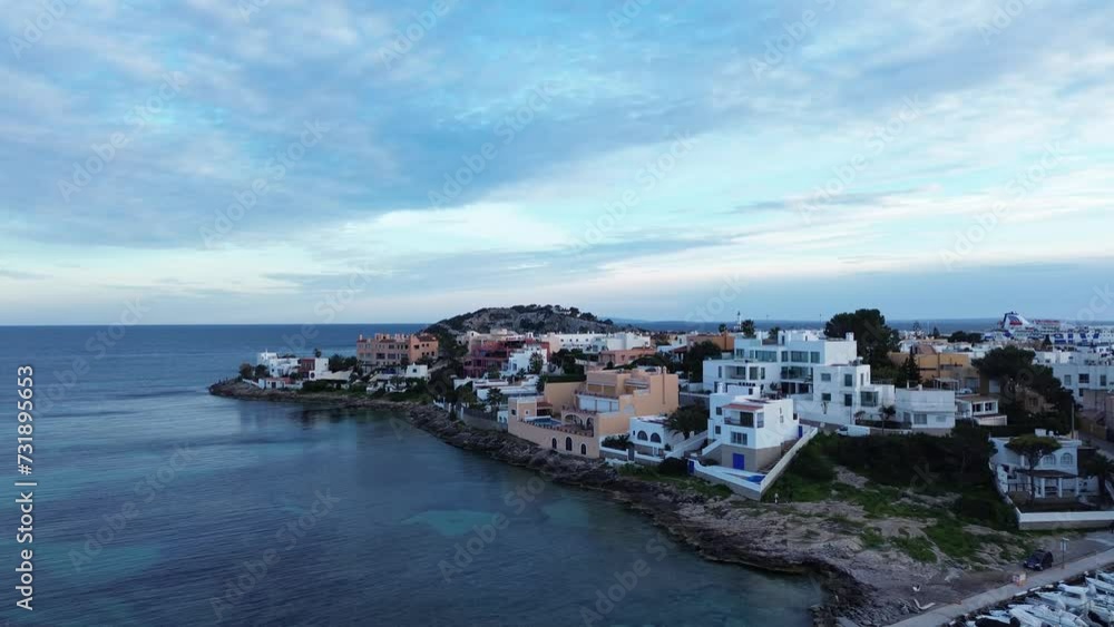 Aerial of buildings on the shore surrounded by the blue sea in Greece under the cloudy sky Aerial of buildings on the shore surrounded by the blue sea in Greece under the cloudy sky