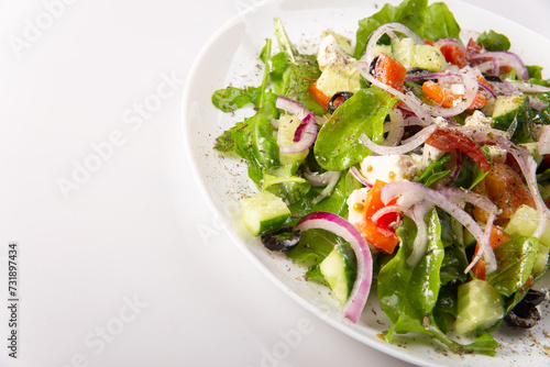 Traditional greek salad with fresh ingredients, feta cheese, olives, red tomatoes, cucumbers and greens