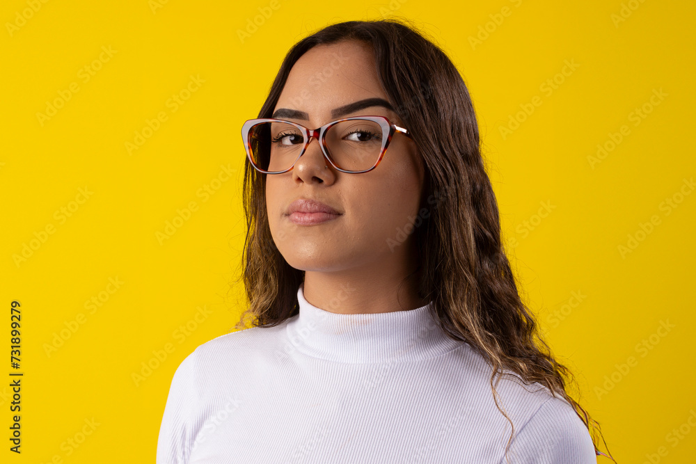 Happy young woman wearing glasses and a white blouse, happy on yellow background