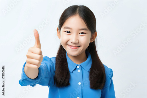 A young girl enthusiastically raises her thumb in approval, showcasing her positive attitude.
