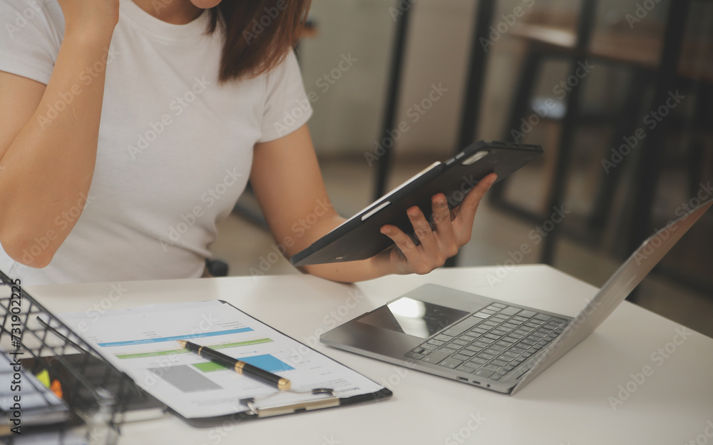 Fototapeta premium Young adult happy smiling Hispanic Asian student wearing headphones talking on online chat meeting using laptop in university campus or at virtual office. College female student learning remotely.