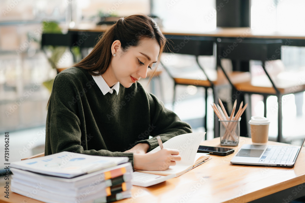 Asian Businesswoman Analyzing Finance on Tablet and Laptop at modern Office Desk tax,