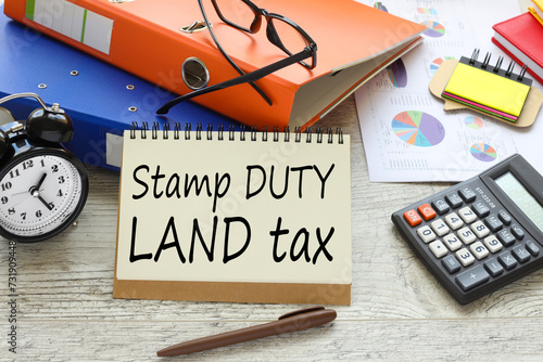 Wallpaper Mural SDLT - Stamp Duty Land Tax text concept on sheet with notepad and calculator. Torontodigital.ca