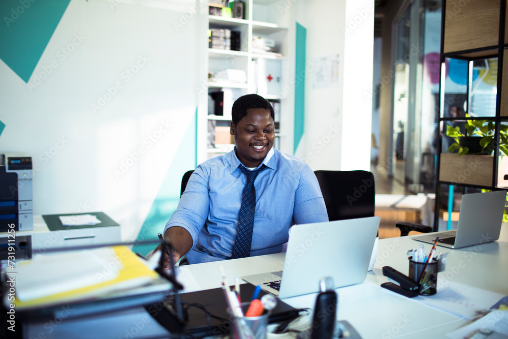 Young black businessman working on office laptop Young black businessman working on office laptop