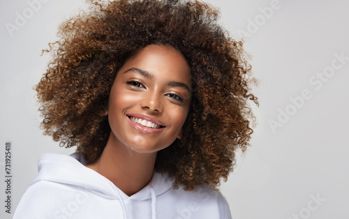 Fashionable young beautiful  woman . Slim girl in an active pose in a white hoodie. Fashion, clothing and style.