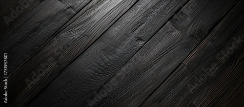 Black clip pattern on dark wooden surface seen from above.