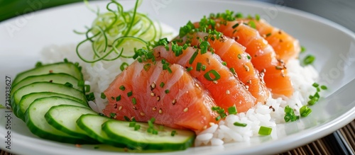 A delicious dish of sushi made with fresh salmon, rice, and cucumber slices, served on a white plate with fines herbes as garnish.
