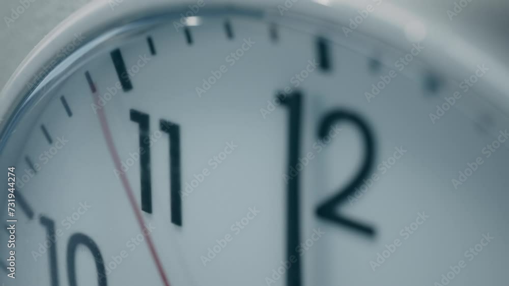 Concept: Deadline Anticipation, Tension and Passage of time. Cinematic High-angle Close-up Shot of White Office Wall Clock with Red Second Hand that Counting Down the Seconds to Twelve. Concept: Deadline Anticipation, Tension and Passage of time. Cinematic High-angle Close-up Shot of White Office Wall Clock with Red Second Hand that Counting Down the Seconds to Twelve.