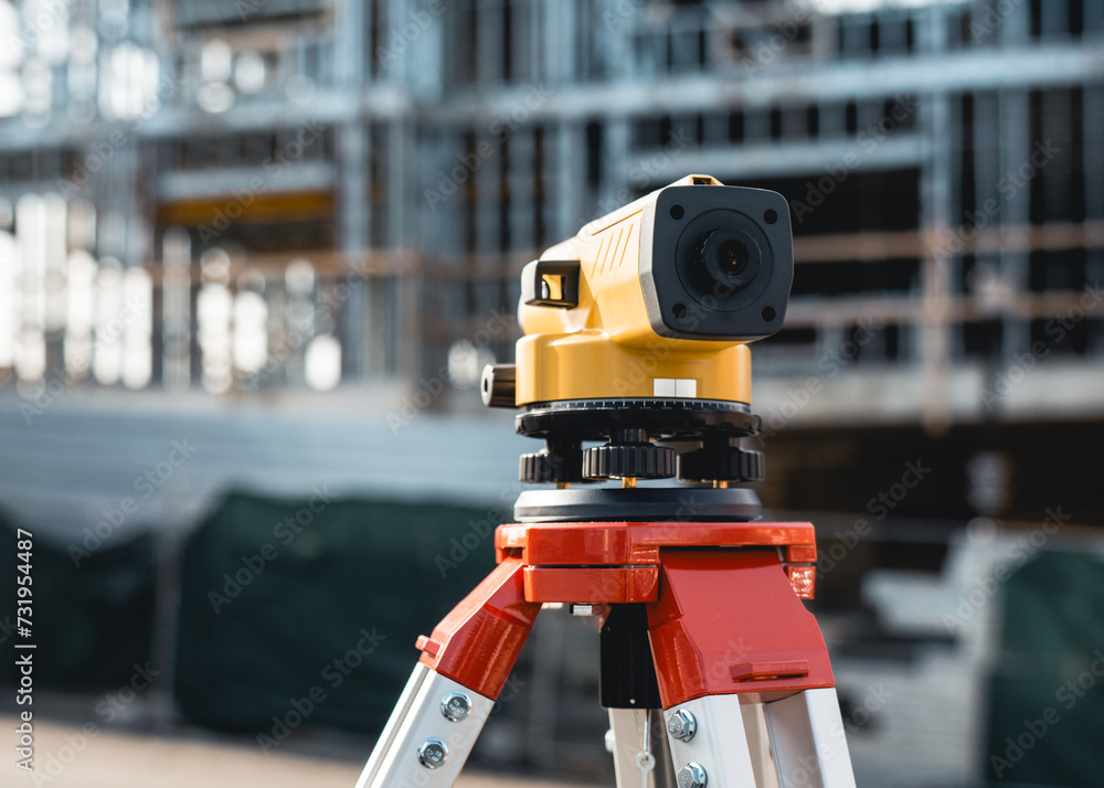 Builders automatic level on a tripod at the construction site Builders automatic level on a tripod at the construction site