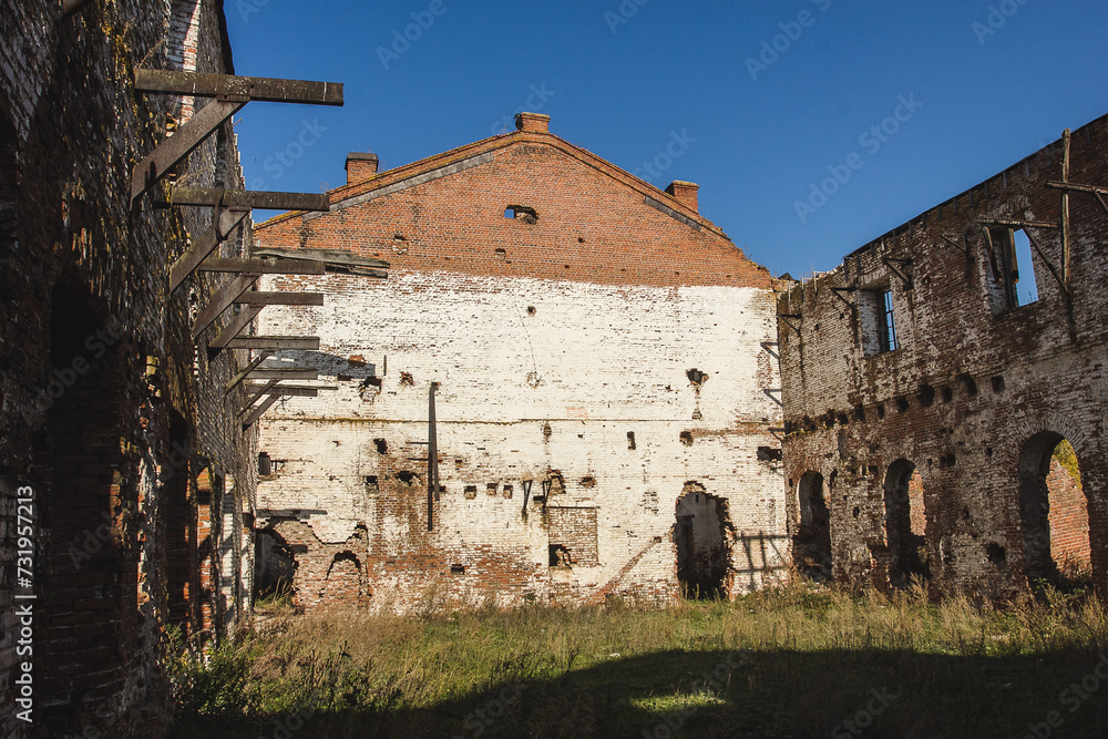 Ruins of an old industrial building with large empty rooms and brick walls. Ruins of an old industrial building with large empty rooms and brick walls.