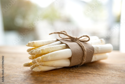 Bunch of fresh white asparagus. Seasonal spring vegetables on a wooden table. Kitchen scene for the seasonal gastronomy. Close-up with short depth of field. photo