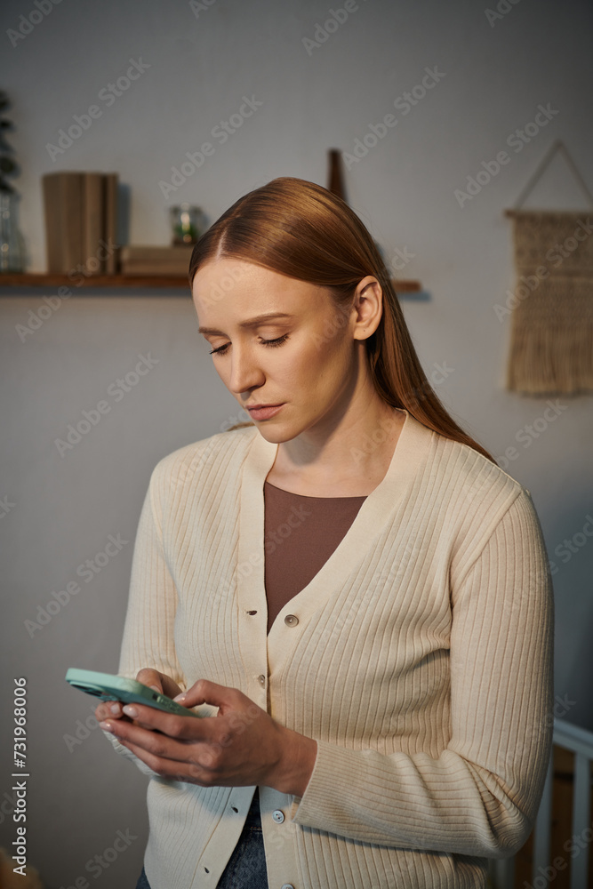 frustrated and upset young woman messaging on mobile phone in dark nursery room at home frustrated and upset young woman messaging on mobile phone in dark nursery room at home