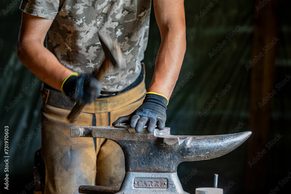 A blacksmith is working with horseshoe A blacksmith is working with horseshoe