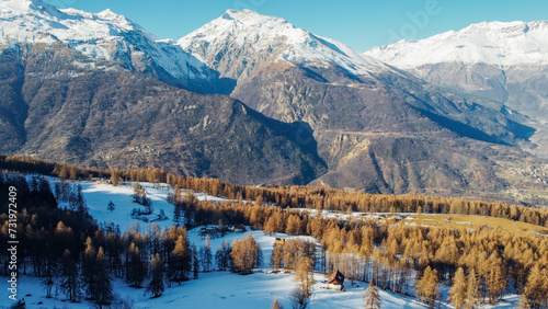 Aerial view of winter landscape with mountain peaks covered with snow and coniferous forest. Natural background.