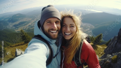 Joyful Hikers Capture Summit Bliss. Couple Selfie Atop Mountain Peak - Adventure, Tech, and Togetherness - Outdoor Enthusiasm and Modern Lifestyle in Nature - Inspirational Travel Moment.