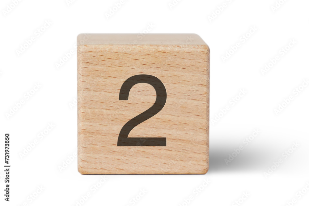 A single wooden block prominently displays a black number two, isolated cutout from background. A single wooden block prominently displays a black number two, isolated cutout from background.