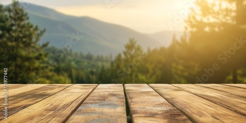 Empty wooden table top with blurred nature background. Mountain with trees in calm sunny day. Table top with copy space for product advertising