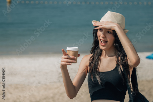 tourist girl with surprised expression and takeaway on the beach photo