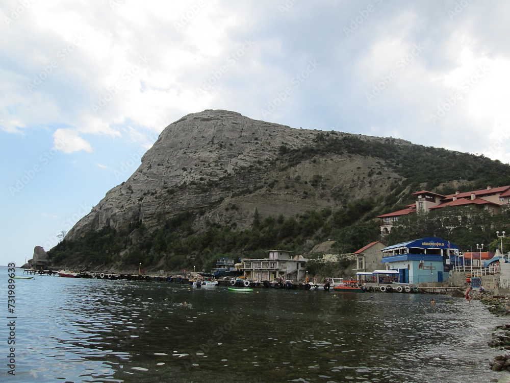 A small town hidden from the sea winds behind a large mountain.