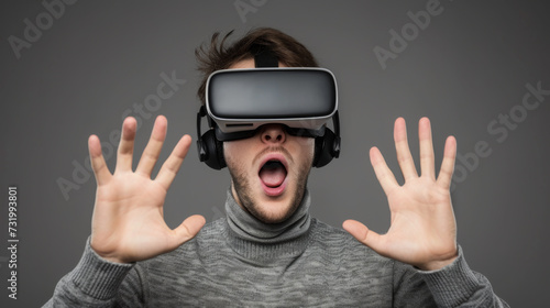 A man wearing a virtual reality headset is reacting with excitement, his hands raised and mouth open in amazement.