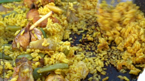 Paella with chicken and vegetables, focus on the crusty rice. photo